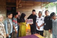 Ketua KPU Tanggamus saat menyerahan santuan kepada istri almarhum Nizar Efendi, anggota KPPS 06 Datar Lebuay, Tanggamus, Kamis 21 Februari 2024. Foto : Herdi/Media Prioritastv.com.