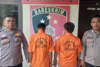 Kedua Tersangka saat akan dijebloskan ke sel tahanan Polsek Sukoharjo, Pringsewu. Dok. Polres Pringsewu.