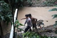 Pihak kepolisian dan saksi saat menunjukan titik ditemukannya korban usai terseret banjir Sungai Tulung Maja, Semaka, Tanggamus, Sabtu 27 April 2024, sore. Foto : Dok. Polres Tanggamus.