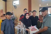 Dewi Handajani saat Menyerahkan Simbolis Bantuan Beras kepada Kepala Pekon Talang Padang. Foto : Asrul Ariski. 