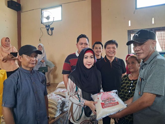 
 Dewi Handajani saat Menyerahkan Simbolis Bantuan Beras kepada Kepala Pekon Talang Padang. Foto : Asrul Ariski. 