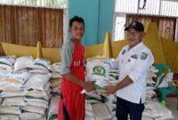Kepala Pekon Fajar Baru Idham Khalid saat Memberikan Bantuan Beras Ketahanan Pangan kepada Warganya, Foto  : Agus Yulianto 