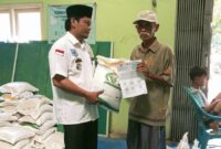 Kepala Pekon Tanjung Rusia saat Membagikan Bantuan Beras kepada Masyarakat.  