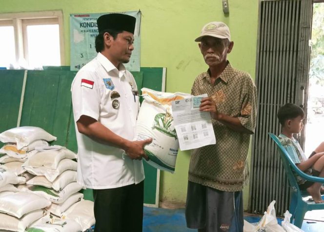 
					Kepala Pekon Tanjung Rusia saat Membagikan Bantuan Beras kepada Masyarakat.  