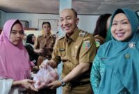 Penjabat (Pj) Bupati Tanggamus, Ir. Mulyadi Irsan saat Memberikan Telur kepada Warga di di Balai Pekon Tanjung Anom, Kecamatan Kota Agung Timur, Senin, 10 Juni 2024. Foto : Asrul Ariski 