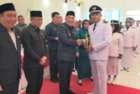 Pj Bupati Tanggamus Mulyadi Irsan saat Menyerahan Surat Pengukuhan Masa Jabatan 8 Tahun kepada Ketua DPC Apdesi Tanggamus, Mirza YB selaku Kakon Negara Batin, Kota Agung Barat, Kamis 4 Juli 2024. Foto : Aldo/Media Prioritastv.com.