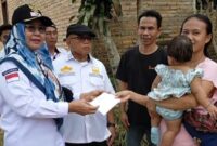 Ketua Apdesi Talang Padang, Tanggamus, Yulistina Heryanti saat menyerahkan bantuan kepada keluarga korban kebakaran di Pekon Sinarpetir, Kamis 18 Juli 2024. Foto : Mustar Arifin/Media Prioritastv.com.