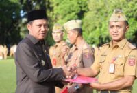 Pj Bupati Lampung Barat, Nukman secara simbolis serahkan bendera merah putih, Senin 5 Agustus 2024.