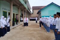 Bhabinkamtibmas Brigpol Gulbudin saat menjadi pembina upacara di MA dan MTs Guppi Sumberejo Tanggamus, Senin 9 September 2024.