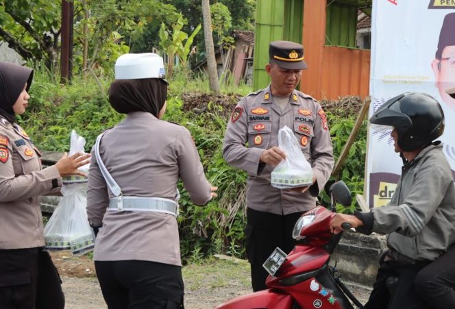 
 Kabag SDM Polres Tanggamus AKP Sarwani saat memberikan nasi kotak Jumat Berkah Polres Tanggamus di jalan masuk Pemkab Tanggamus, Jumat 4 Oktober 2024.