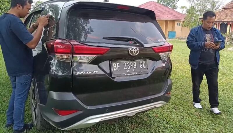 Warga saat menemukan mobil dinas camat Negero Katon, Pesawaran memuat banner pasangan Calon Bupati dan Wakil Bupati, Jumat 4 Oktober 2024.
