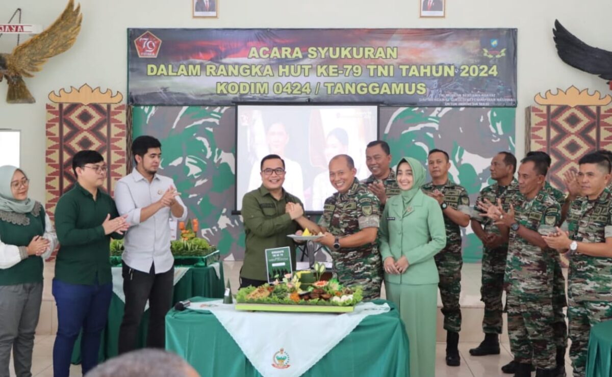 Kajari Pringsewu Raden Bagus Wisnu Wicaksono saat menyerahkan potongan tumpeng kepada Dandim 0424 Tanggamus Letkol Inf. Vicky Heru Harsanto di Makodim setempat, Sabtu 5 Oktober 2024 | Herdi/Media Prioritastv.com.