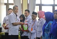 Wasisno Sembiring menyerahkan plakat Adiwiyata saat  Bimtek PBLHS di Aula Kagungan Setdakab, Kamis, 10 Oktober 2024. Kegiatan ini dihadiri oleh para perwakilan guru sekolah di Kabupaten Lampung Barat.