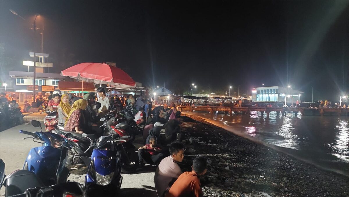 Masyarakat berkumpul di tepian pantai duduk-duduk menunggu kemunculan fenomena ikan naik ke daratan di Pantai Dermaga Dua Kota Agung, Tanggamus, Minggu 9 November 2024, malam | Herdi/Media Prioritastv.com.