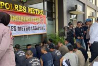 Polres Metro Lampung saat merilis 4 tersangka pengeroyokan dan sejumlah tersangka lain di Mapolres setempat, Senin 11 November 2024.