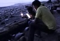 Masyarakat Pekon Badak saat mencari Signal Komunikasi Data di Pinggir Pantai, Senin 11 November 2024.
