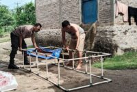 Bhabinkamtibmas Polsek Wonosobo Bripka Mujiono Bersama Warga saat Membuat Kolam Budidaya Ikan Lele. Foto : Asrul Ariski/Media Prioritastv.com. 