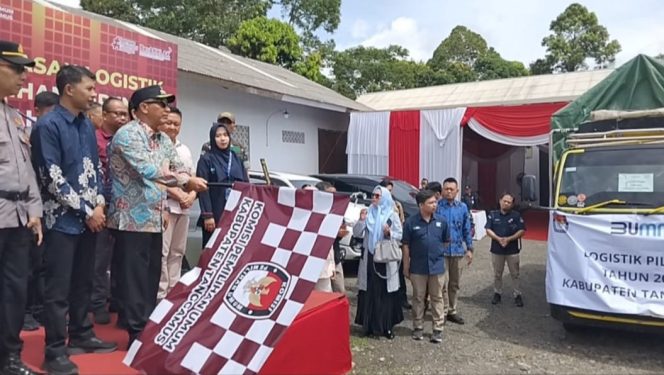 
 Pj Bupati Tanggamus Muyadi Irsan mengangkat bendera tanda pelepasan logistik Pilkada 2024 ke Cukuh Balak dan Pematang Sawa di Gudang Logistik KPU Pekon Gisting Atas, Minggu 24 November 2024 | Herdi/Media Prioritastv.com.