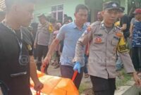 Polisi saat mengevakuasi jasad korban pembunuhan di Lampung Utara.