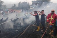 Petugas pemadam saat melakukan proses menjinakan api kebakaran kapal nelayan eks Kapal Siwa Jaya di Dermaga Batu Pasar Madang, Kota Agung, Tanggamus, Minggu 15 Desember 2024 | Herdi/Media Prioritastv.com.