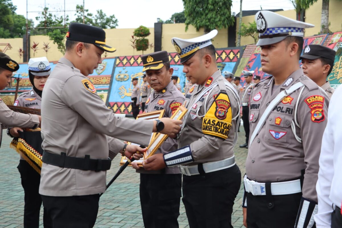 Kapolres Tanggamus AKBP Rivanda saat menyerahkan penghargaan kepada Kasat Lantas Polres Tanggamus Iptu Made Agus Dwi Dayana, Selasa 17 Desember 2024 | Dok. Humas Polres Tanggamus.