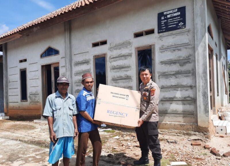 Bripka Noprian, S.H.,M.H., Bhabinkamtibmas Polsek Pulau Panggung saat memberikan sebuah kipas untuk musholah Al-Muttaqien yang bertempat di Pekon Sinar Mancak, Kecamatan Pulau Panggung, Kabupaten Tanggamus. Foto : Asrul Ariski | Media Prioritastv.com.