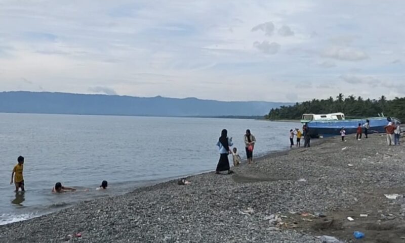 Wisatawan menikmati ombak pantai Muara Indah, Kota Agung, Tanggamus, Rabu 25 Desember 2024 | Herdi/Media Prioritastv.com.
