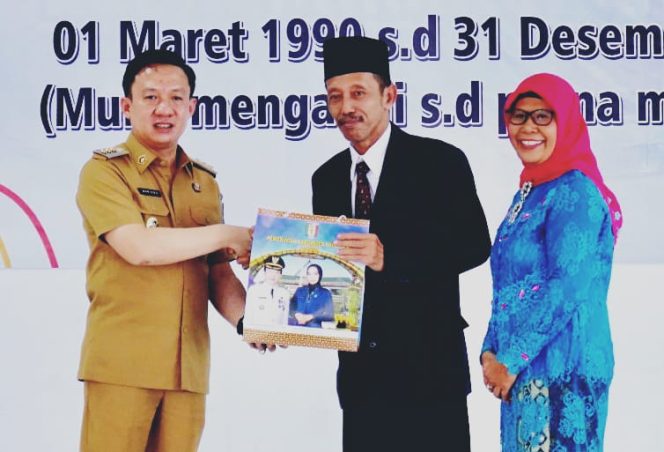 
 Pj Bupati Pringsewu Marindo Kurniawan saat memberikan kenang-kenangan kepada  Joko Hermanto, Senin 30 Desember 2024.