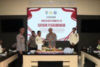 Kapolres Tanggamus AKBP Rivanda saat memberikan potongan tumpeng kepada salah satu Satpam termuda di Aula Wirasatya, Rabu 8 Desember 2025 | Dok. Polres Tanggamus.