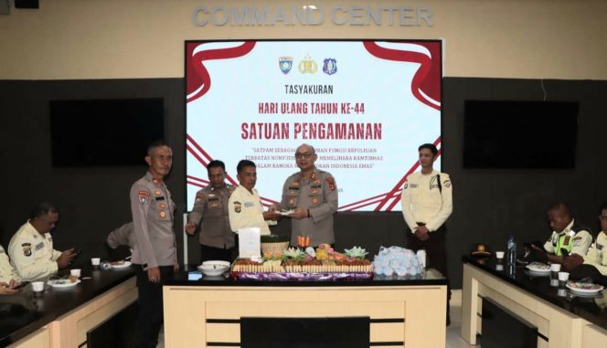 
 Kapolres Tanggamus AKBP Rivanda saat memberikan potongan tumpeng kepada salah satu Satpam termuda di Aula Wirasatya, Rabu 8 Desember 2025 | Dok. Polres Tanggamus.