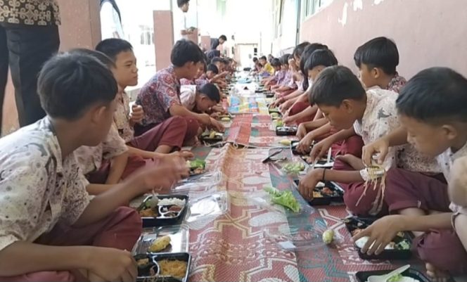 
 Antusiasme para siswa saat menikmati makan bergizi gratis yang diberikan oleh Gibran Center Tanggamus, Rabu 8 Januari 2025 | Herdi/Media Prioritastv.com.