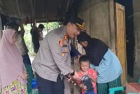 Senyum bahagia putra Surtini saat diberikan mainan mobilan oleh Kapolres Tanggamus AKBP Rivanda, Rabu 15 Januari 2025.