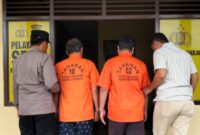 Kedua tersangka saat akan dijebloskan ke sel tahanan di Polsek Sukoharjo, Pringsewu, Jumat 24 Januari 2025 | Dok. Humas Polres Pringsewu.