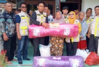 Ketua Apdesi Semaka Tanggamus Abdul Karim saat menyerahkan bantuan kepada Nuriah korban kebakaran di Sukaraja, Selasa 28 Januari 2025.