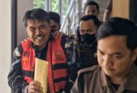 Senyum khas Sekda Pringsewu, Heri Iswahyudi saat Digelandang Penyidik Kejari Pringsewu, Kamis 30 Januari 2025 | Dok. Kejari Pringsewu.