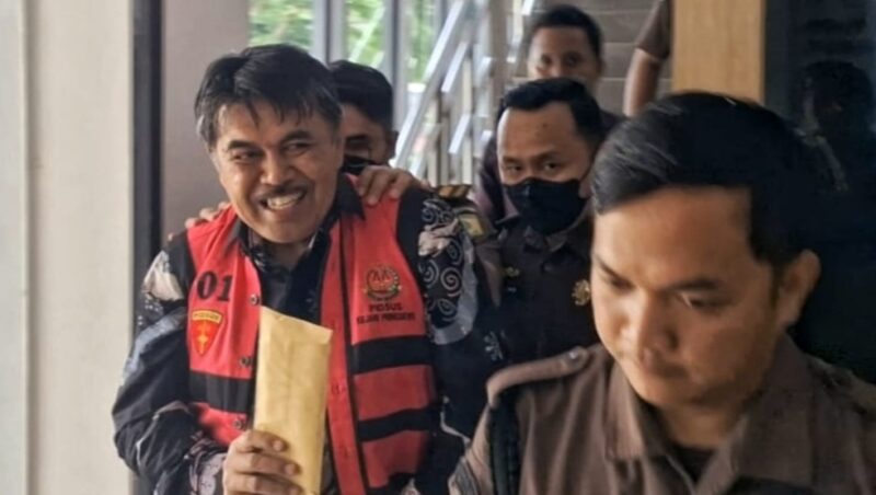 Senyum khas Sekda Pringsewu, Heri Iswahyudi saat Digelandang Penyidik Kejari Pringsewu, Kamis 30 Januari 2025 | Dok. Kejari Pringsewu.