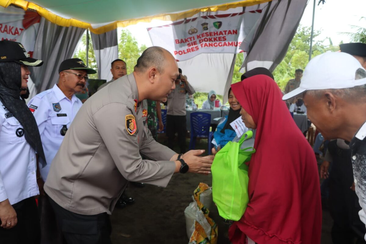 Kapolres Tanggamus AKBP Rivanda saat menyerahkan bakan pokok kepada masyarakat di lapangan bola Cukuh Batu, Terbaya, Kota Agung, Rabu 5 Februari 2025.