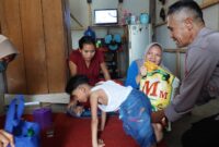 Anggota Polres Tanggamus saat kunjungan sosial dan menyerahkan bantuan di RT 004 RW 003 Pekon Terbaya, Kota Agung, Tanggamus, Selasa 11 Februari 2025 | Dok. Humas Polres Tanggamus.