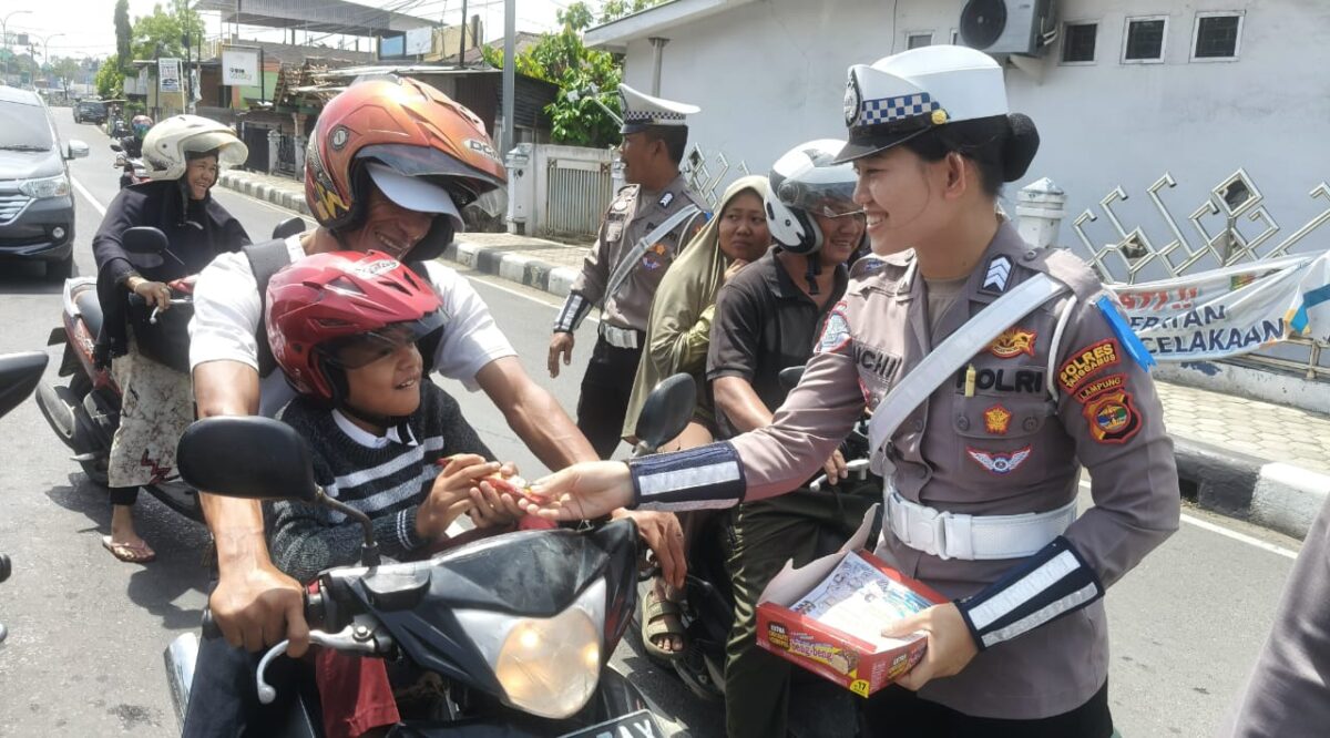 Anggota Sat Lantas Polres Tanggamus saat memberikan hadiah coklat kepada pengendara yang patuh di simpang Lampu Merah, Kota Agung, Selasa 11 Februari 2025 | Herdi/Media Prioritastv.com.