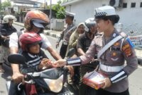 Anggota Sat Lantas Polres Tanggamus saat memberikan hadiah coklat kepada pengendara yang patuh di simpang Lampu Merah, Kota Agung, Selasa 11 Februari 2025 | Herdi/Media Prioritastv.com.
