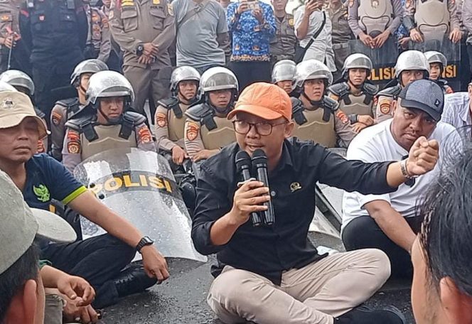 
 Anggota DPRD Lampung dari Komisi V, Syukron Muchtar saat menemui massa aksi yang menggelar unjuk rasa di depan Gedung DPRD Lampung, Senin 17 Februari 2025 | Tiondon/Media Prioritastv.com.