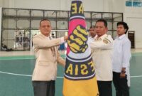 Ketua Pengurus Provinsi Taekwondo Indonesia Lampung saat Menyerahkan Bendera Pataka Kepada Irwan Prianto, S.H., di Gedung Sport Center UIN Raden Intan Bandar Lampung Minggu 23 Februari 2025 | Dok. Pengkab TI Pringsewu.