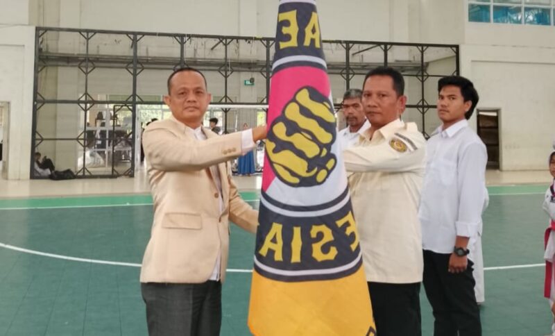 Ketua Pengurus Provinsi Taekwondo Indonesia Lampung saat Menyerahkan Bendera Pataka Kepada Irwan Prianto, S.H., di Gedung Sport Center UIN Raden Intan Bandar Lampung Minggu 23 Februari 2025 | Dok. Pengkab TI Pringsewu.