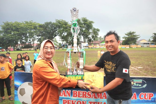 
 Kepala Pekon Tuti Arifin Kepala Pekon Tekad saat Menyerahkan Tropi Piala Juara Satu kepada Tim Hinode. Foto : Asrul Ariski/ Media Prioritastv.com. 