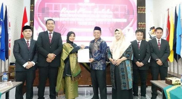 Ketua KPU Pringsewu, Dewi Eliyasari saat menyerahkan surat keputusan kepada Bupati Terpilih Riyanto Pamungkas dan Wakil Bupati Terpilih, Kamis 6 Februari 2025.