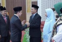 Pj Bupati Pringsewu, Marindo Kurniawan mengucapkan selamat kepada Riyanto Pamungkas dan Umi Laila setelah ditetapkan sebagai Bupati dan Wakil Bupati Terpilih Pringsewu periode 2025-2030 di gedung DPRD setempat, Senin (10/2/2025).