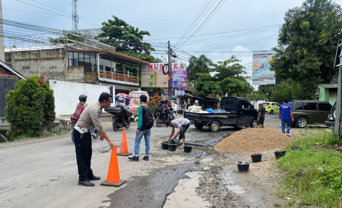Para pemuda yang sedang menambal jalan berlubang didepan Mapolsek Pringsewu Kota, Selasa 4 Maret 2025 | Dok. Polres Pringsewu.