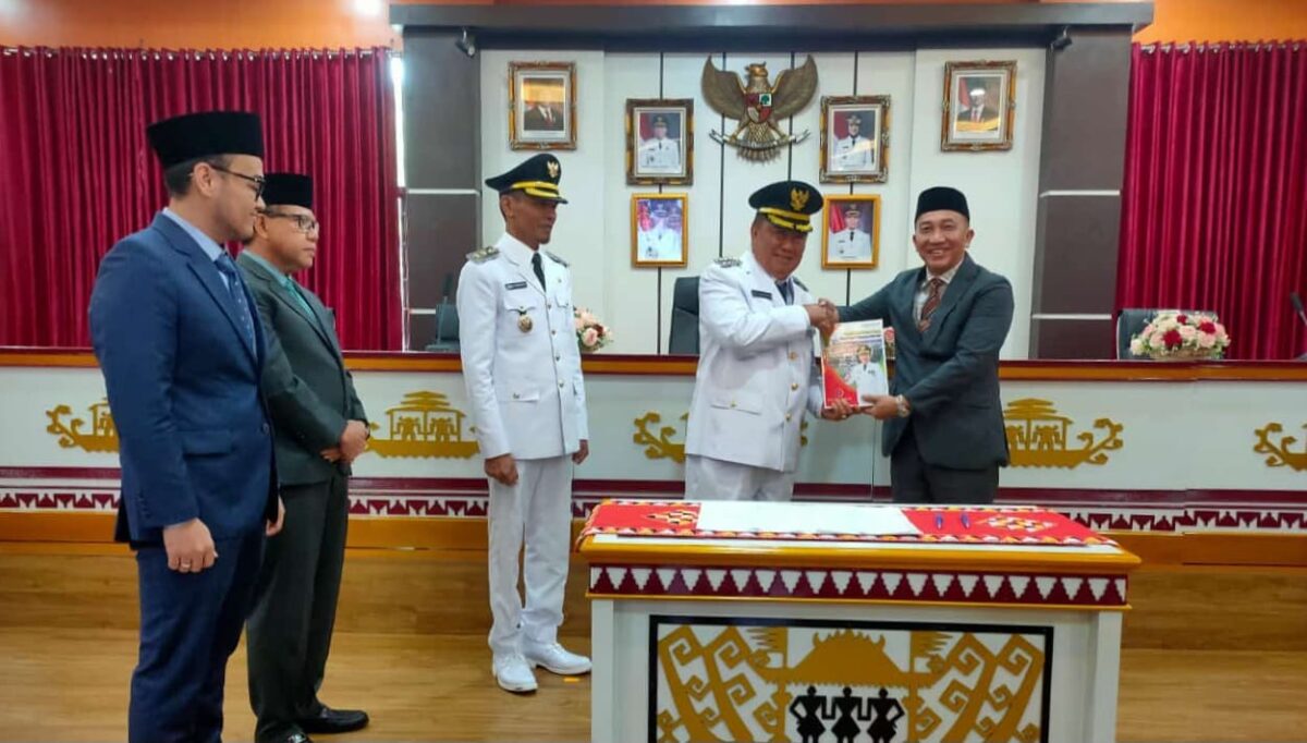 Penyerahan cindramata dari Pj Bupati Tanggamus 2023 - 2025 Mulyadi Irsan kepada Bupati Tanggamus 2025 - 2030 Moh Saleh Asnawi usai penandatangan memory sertijab, Kamis 6 Februari 2025 | Herdi/Media Prioritastv.com.