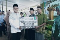 Bupati Pringsewu Riyanto Pamungkas saat menyerahkan bantuan rumah tidak layak huni secara simbolis kepada penerima saat safari ramadhan di Masjid Nurul Huda, Pekon Sumber Bandung, Kecamatan Pagelaran Utara, Jumat (7/3/2025) petang | Dok. Kominfo Pringsewu.