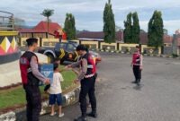 Anggota Sat Samapta Polres Tanggamus berbagi takjil kepada anak-anak ngabuburit di Komplek Pemkab Tanggamus, Jumat 7 Maret 2025 | Dok. Humas Polres Tanggamus.